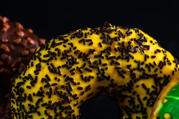 Donuts Frais Colorés Savoureux Avec Des Saupoudres Sur Fond Noir — Photo