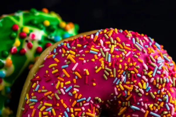 Donuts Frais Colorés Savoureux Avec Des Saupoudres Sur Fond Noir — Photo