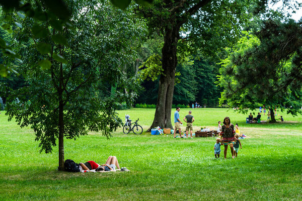 Люди, отдыхающие на пикнике и веселящиеся во время коронавирусного кризиса в парке и садах области Могосоая в Бухаресте, Румыния, 2020 г..