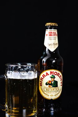 Birra Morreti birası ve arka planda bira bardağı. Romanya 'nın Bükreş kentinde 2021 yılında çekilen illüstrasyon fotoğrafı