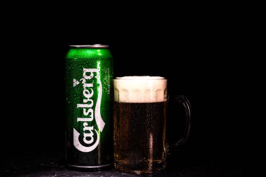Arka planda bir kutu Carlsberg birası ve bira bardağı. Romanya 'nın Bükreş kentinde 2021 yılında çekilen illüstrasyon fotoğrafı