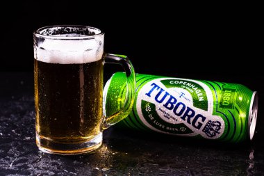 Siyah arka planda bir kutu Tuborg birası ve bira bardağı. Romanya 'nın Bükreş kentinde 2021 yılında çekilen illüstrasyon fotoğrafı