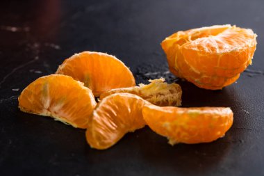 Siyah arka planda dilimlenmiş portakallar. Siyah üzerine izole edilmiş taze meyve.