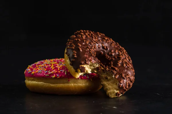 Donuts Frais Colorés Savoureux Avec Des Saupoudres Sur Fond Noir — Photo