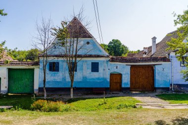 Romanya 'daki Viscri köyünün manzarası. Romanya 'nın Viscri kentindeki ortaçağ Sakson köyündeki geleneksel evleri boyamış.