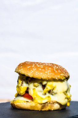 Beyaz arka planda erimiş peynirli taze sığır etli çizburger.