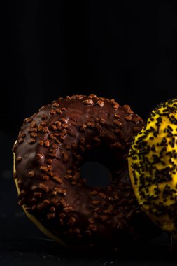 Siyah arka planda serpiştirilmiş taze renkli çörekler.