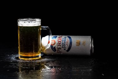 Arka planda bir kutu Peroni Nastro Azzurro birası ve bira bardağı. Romanya 'nın Bükreş kentinde 2021 yılında çekilen illüstrasyon fotoğrafı