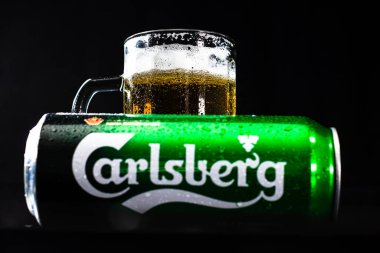 Arka planda bir kutu Carlsberg birası ve bira bardağı. Romanya 'nın Bükreş kentinde 2021 yılında çekilen illüstrasyon fotoğrafı
