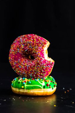 Isırılmış pembe jöleli donut. Renkli donutları kapat.
