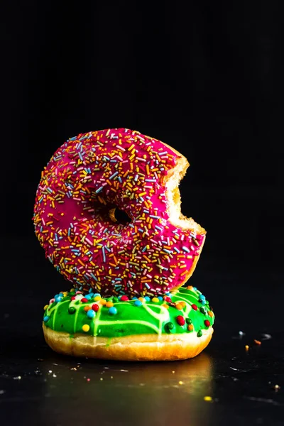 Isırılmış pembe jöleli donut. Renkli donutları kapat.