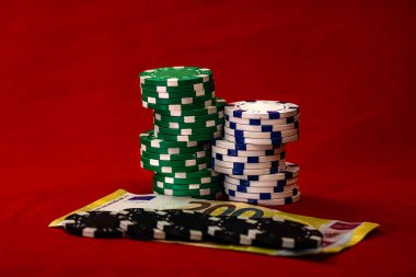 Kırmızı arkaplanda parası olan poker çipleri yığını, EURO para birimi