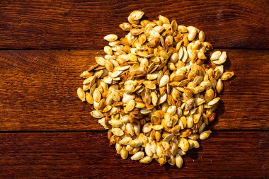 Ahşap masada kavrulmuş tuzlu kabak çekirdeği.