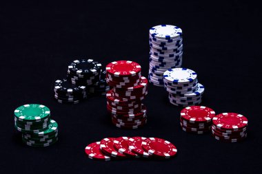 Siyah arkaplanda poker çipleri yığını