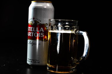 Bir kutu Stella Artois birası ve arka planda bira bardağı. Romanya 'nın Bükreş kentinde 2021 yılında çekilen illüstrasyon fotoğrafı