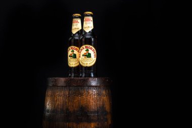 Bir şişe Birra Moretti birası. Ahşap fıçının üzerinde, koyu arkaplanlı. Bükreş, Romanya, 2021