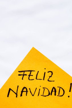 Feliz Navidad (Mutlu Noeller) el yazısı, fotokopi alanı olan turuncu kağıda izole edilmiş. Anımsatıcı üzerine metin yazılıyor.