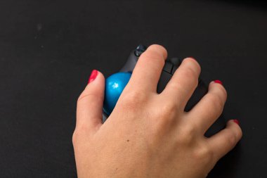 El bilgisayar faresi kullanıyor. Siyah ahşap arka planda bilgisayar faresinin elini kapat