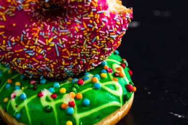 Siyah arka planda serpiştirilmiş taze renkli çörekler.