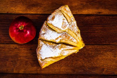 Kırsal ahşap masada tarçınlı dilimlenmiş elmalı turta.