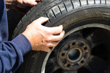 Romanya 'nın Bükreş kentindeki araba garajında araba tamircisi lastik değiştiriyor.