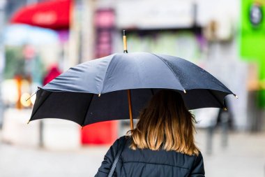 Romanya 'nın Bükreş kentinde 2021' de yağmurlu bir günde sokakta şemsiyesi olan insanlar