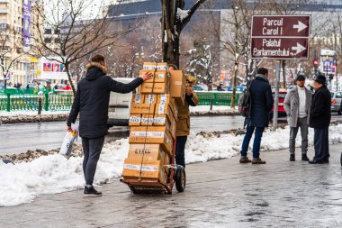 Bükreş, Romanya, 2021 'de karton kutular taşıyan insanlar