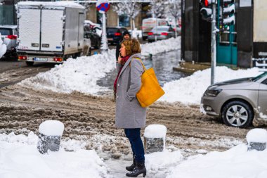 Romanya 'nın Bükreş kentindeki karlı yolda taksi ya da otobüs bekliyor.