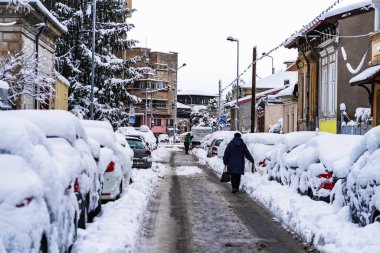 2021 'de Romanya' nın Bükreş kentinde karlı yolda yürüyorum. Sokakta kar, karlı yol, kış günü