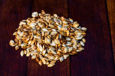 Ahşap masada kavrulmuş tuzlu kabak çekirdeği.