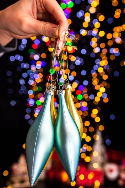 Memegang Dekorasi Natal Terhadap Latar Belakang Lampu Bokeh — Stok Foto