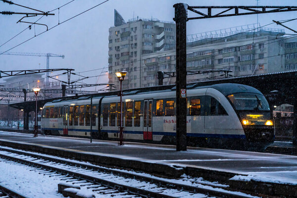 Вид зимнего поезда. Трейн на платформе Северной железнодорожной станции Бухарест (Gara de Bucuresti) в Бухаресте, Румыния, 2021 год