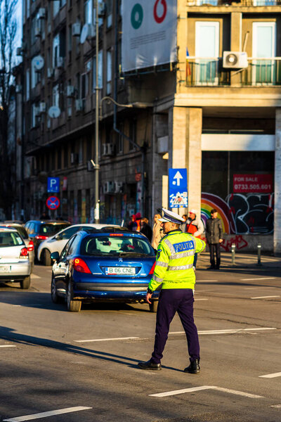 Police agent, Romanian Traffic Police (Politia Rutiera) directing traffic during  rush hour in downtown Bucharest, Romania, 2021