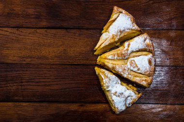 Kırsal ahşap masada tarçınlı dilimlenmiş elmalı turta.