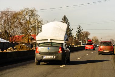 Mattress on car roof, Dacia Logan carrying mattresses on roof in Bucharest, Romania, 2021 clipart