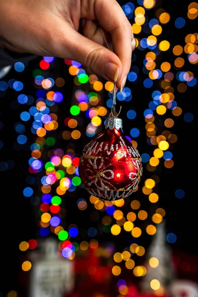 Het Houden Van Kerstversiering Tegen Bokeh Lichten Achtergrond — Stockfoto