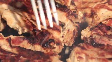 Alevler ve duman yükselirken kızgın ızgarada cızırdayan et. Mükemmel ızgara izleri olan sulu biftekler, açık hava barbekü pişirmenin sıcaklığını ve lezzetini yakalar.