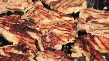 Alevler ve duman yükselirken kızgın ızgarada cızırdayan et. Mükemmel ızgara izleri olan sulu biftekler, açık hava barbekü pişirmenin sıcaklığını ve lezzetini yakalar.