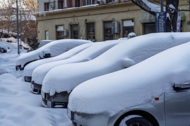 Kar yağdıktan sonra arabalara kar yağar. Kış manzarası ve karla kaplı arabalar