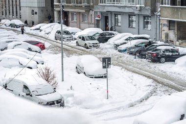 Kar yağdıktan sonra arabalara kar yağar. Kış manzarası ve karla kaplı arabalar