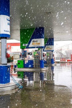 Bir OMV benzin istasyonunun dışı. Benzin pompaları ve arabalar kar yağarken yakıt ikmali yapıyorlar.