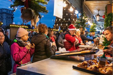 Bükreş Noel Pazarı 'nda insanlar eğleniyor ve yemek yiyor.