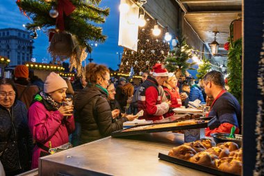Bükreş Noel Pazarı 'nda insanlar eğleniyor ve yemek yiyor.