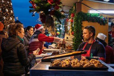 Bükreş Noel Pazarı 'nda insanlar eğleniyor ve yemek yiyor.