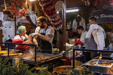 Bükreş Noel Pazarı 'nda insanlar eğleniyor ve yemek yiyor.