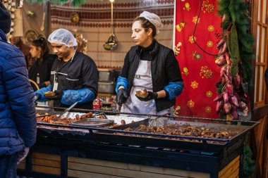 Bükreş Noel Pazarı 'nda insanlar eğleniyor ve yemek yiyor.