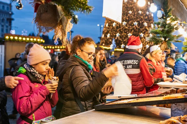 Bükreş Noel Pazarı 'nda insanlar eğleniyor ve yemek yiyor.