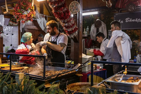 Bükreş Noel Pazarı 'nda insanlar eğleniyor ve yemek yiyor.