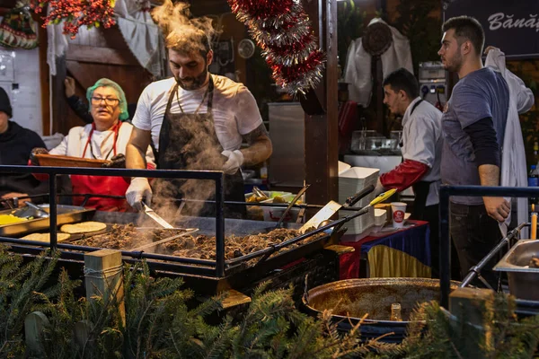 Bükreş Noel Pazarı 'nda insanlar eğleniyor ve yemek yiyor.