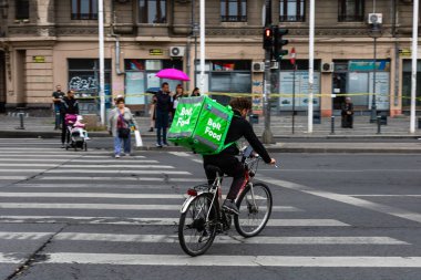 Bisikletli bir Bolt gıda kuryesi Romanya 'nın Bükreş kentinde yiyecek dağıtıyor